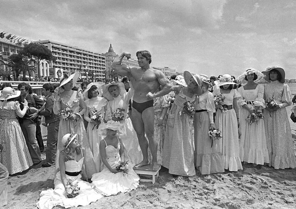 1977年5月20日，還沒成好萊塢巨星的阿諾以「環球先生」頭銜在沙灘曬肌肉（圖片來源：美聯社）