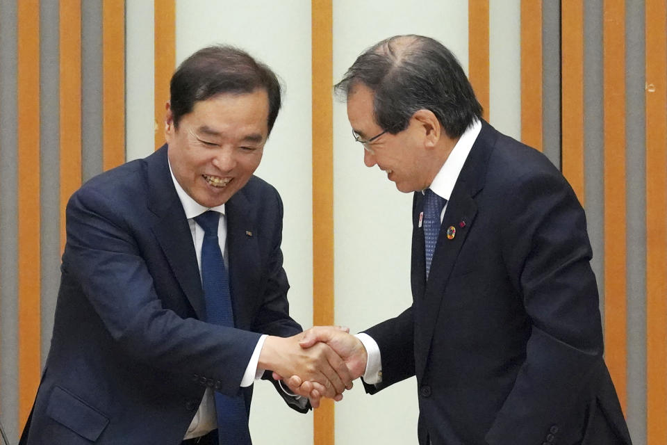 Masakazu Tokura, right, chairman of Keidanren, and Kim Byung-joon, left, acting chairman of the Korean National Federation of Economic Organizations (ZENKEIREN), shake hands after their press conference on "Japan-Korea Partnership Fund for the Future" Wednesday, May 10, 2023, in Tokyo. (AP Photo/Eugene Hoshiko)