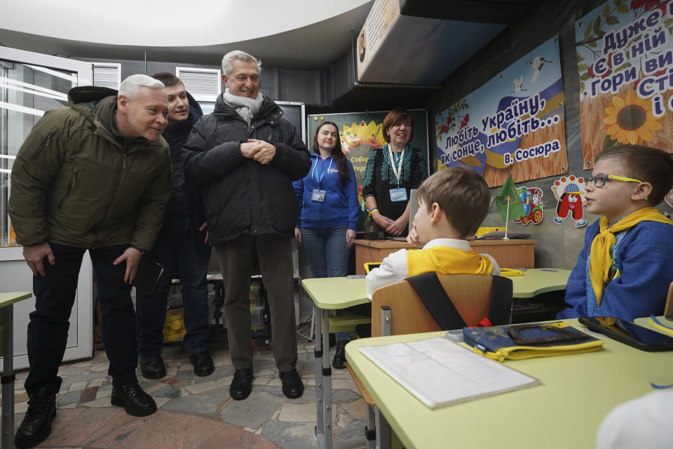 CORRECTS SPELLING OF SURNAME TO GRANDI - United Nations High Commissioner for Refugees Filippo Grandi, centre, speaks with pupils as he visits a school in Kharkiv, Ukraine, Monday, Jan. 22, 2024. (AP Photo/Andrii Marienko)