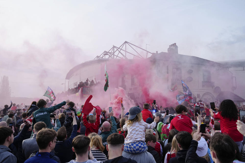 Members of the Wrexham FC soccer team ride on an open top bus as they celebrate promotion to the Football League in Wrexham, Wales, Tuesday, May 2, 2023. (AP Photo/Jon Super)