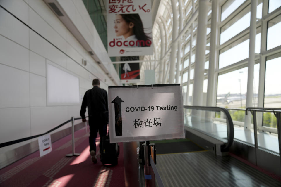 A sign directs passengers arriving in Tokyo, Monday, July 19, 2021, to get their COVID-19 tests before being allowed to enter the country. (AP Photo/Natacha Pisarenko)