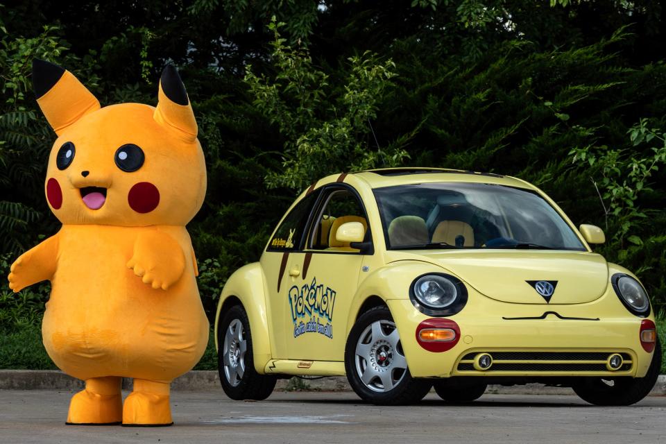 A Pikachu mascot stands by a Volkswagen Bug that has been customized as a Pokémon car that talks and sings in Camden, Monday, July 10, 2023.