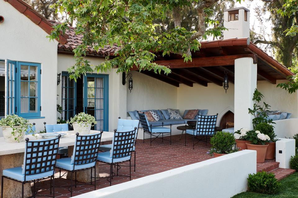 A Formations dining table and chairs from Janus et Cie set the stage for alfresco dinners on the back terrace. The custom banquette features fabric by Mariaflora; the cocktail table is from Hollywood at Home.