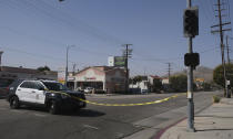 Strong Santa Ana winds in Chatsworth, Calif., blew across power lines causing them to arc and transformers to explode. Power was out for street signs, businesses and residents. A LAPD vehicle blocks a closed Devonshire St. at Owensmouth Ave., east of Topanga Canyon Blvd. on Thursday, Oct. 10, 2019. (Dean Musgrove/The Orange County Register via AP)