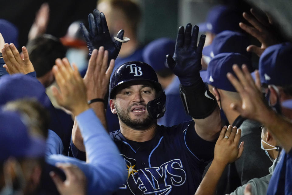 Tampa Bay Rays' Mike Zunino is greeted in the dugout after hitting a two-run home run off Baltimore Orioles relief pitcher Travis Lakins Sr. during the fifth inning of a baseball game, Tuesday, May 18, 2021, in Baltimore. Rays' Yandy Diaz scored on the home run. (AP Photo/Julio Cortez)