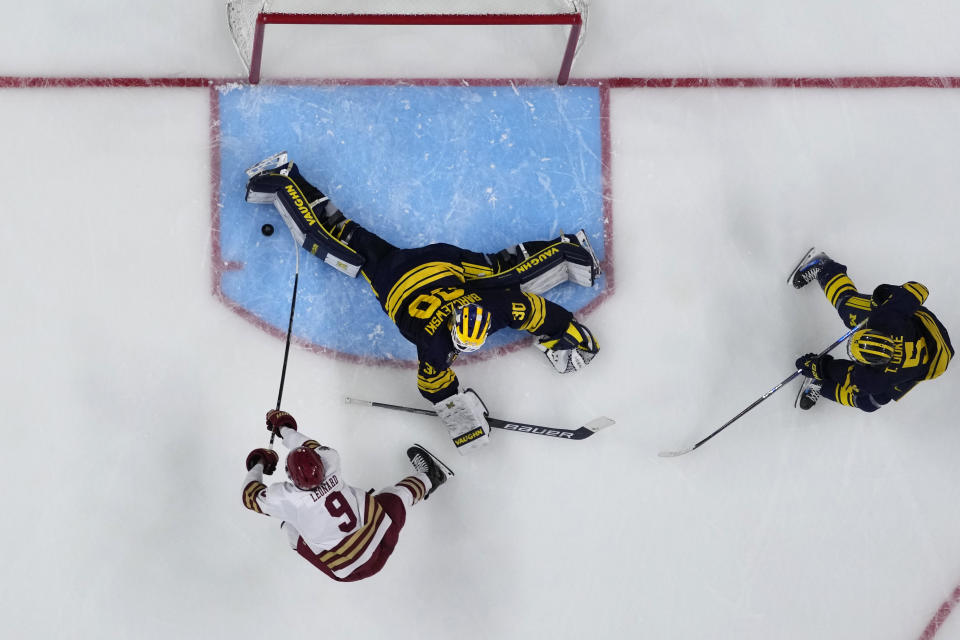 Michigan goaltender Jake Barczewski (30) stops a shot by Boston College forward Ryan Leonard (9) during the second period of a Frozen Four semifinal in the men's NCAA college hockey tournament Thursday, April 11, 2024, in St. Paul, Minn. (AP Photo/Abbie Parr)