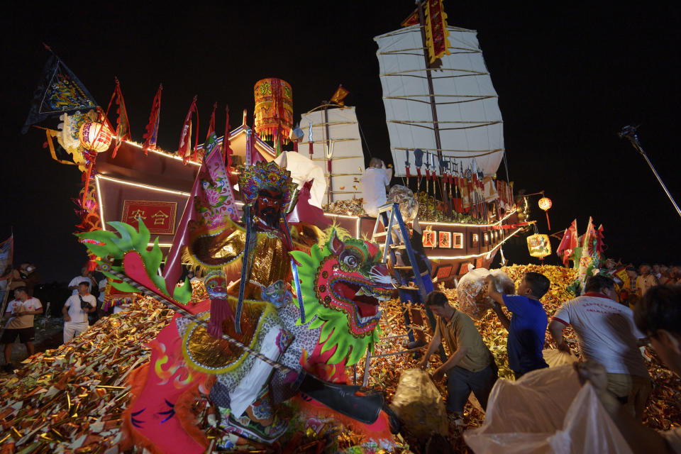 Ethnic Chinese devotees prepare a Wangkang ship during night culminating in a send-off ceremony where the barge was set aflame so that the collected spirits can symbolically sail into another realm during Wangkang or "royal ship" festival in Malacca, Malaysia, Thursday, Jan. 11, 2024. The Wangkang festival was brought to Malacca by Hokkien traders from China and first took place in 1854. Processions have been held in 1919, 1933, 2001, 2012 and 2021. (AP Photo/Vincent Thian)