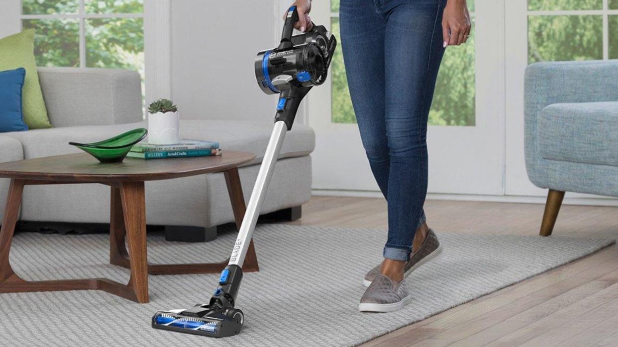  The Hoover ONEPWR Blade+ on a carpet, being pushed by a woman 