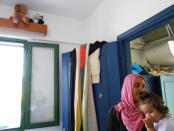 A Syrian woman carrying her daughter looks on, as she stays in a former Peloponnese tourist resort that has been turned into a migrant home near the town of Myrsini, southwest of Athens, Greece, August 13, 2016. Picture taken August 13, 2016. REUTERS/Michele Kambas