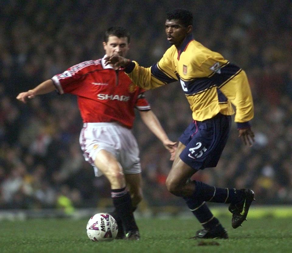 Roy Keane and Nwankwo Kanu do battle for Manchester United and Arsenal in a classic 1990s clash (PA)