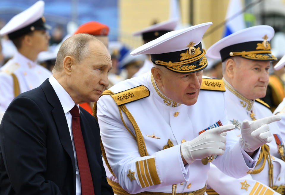 Russian President Vladimir Putin, left, listens to Admiral Nikolai Yevmenov, Commander-in-Chief of the Russian Navy, second right, while watching the Navy Day parade in St.Petersburg, Russia, Sunday, July 25, 2021. (Alexei Nikolsky, Sputnik, Kremlin Pool Photo via AP)