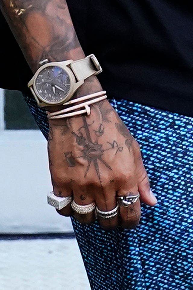 Detail of Lewis Hamilton's right hand and wrist with a watch, bracelet and a ring on each finger