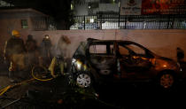 Firefighters douse a car after demonstrators set it on fire during a protest against a new citizenship law in Delhi, India, December 20, 2019. REUTERS/Adnan Abidi