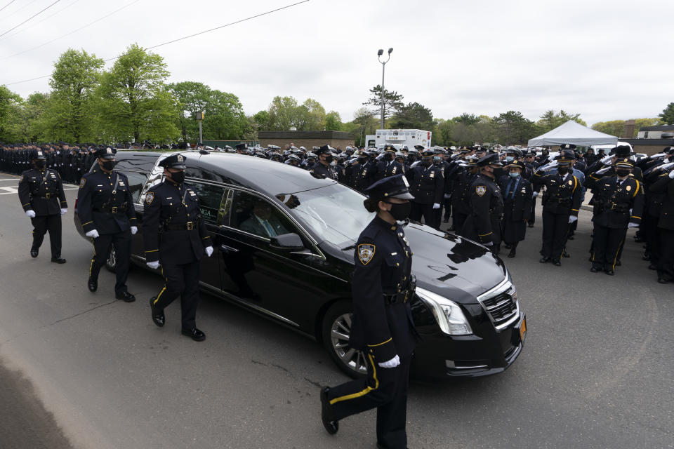 Thousands of police officers line the street as the hearse bearing New York police officer Anastasios Tsakos leaves the St. Paraskevi Greek Orthodox Shrine Church, Tuesday, May 4, 2021, in Greenlawn, N.Y. Tsakos was at the scene of an accident on the Long Island Expressway when he was struck and killed by an allegedly drunk driver a week ago. (AP Photo/Mark Lennihan)