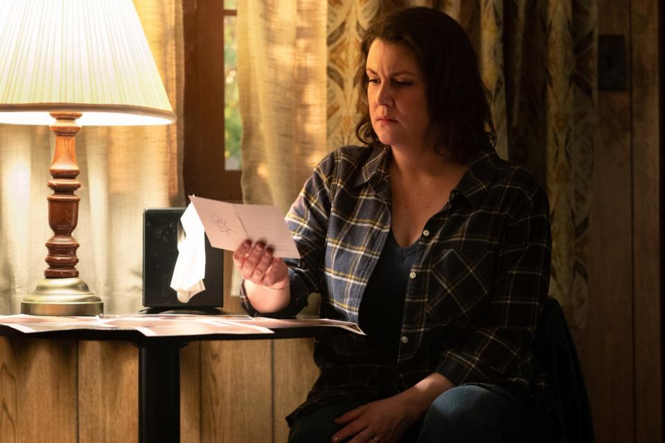 Melanie's character sitting by a side table with a letter in her hand