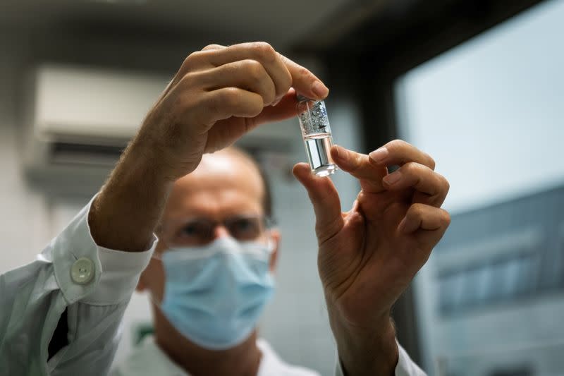 Laboratory assistant holds a tube with Russia's "Sputnik-V" vaccine against the coronavirus disease (COVID-19) at the National Institute of Pharmacy and Nutrition in Budapest