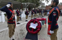 A police contingent salutes during a funeral for a police officer, a victim of Monday's suicide bombing, in Peshawar, Pakistan, Feb. 2, 2023. A suicide bomber who killed 101 people at a mosque in northwest Pakistan this week had disguised himself in a police uniform and did not raise suspicion among guards, the provincial police chief said on Thursday. (AP Photo/Muhammad Sajjad)