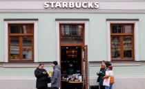 FILE PHOTO: People wait for their orders outside a Starbucks coffee shop in Moscow