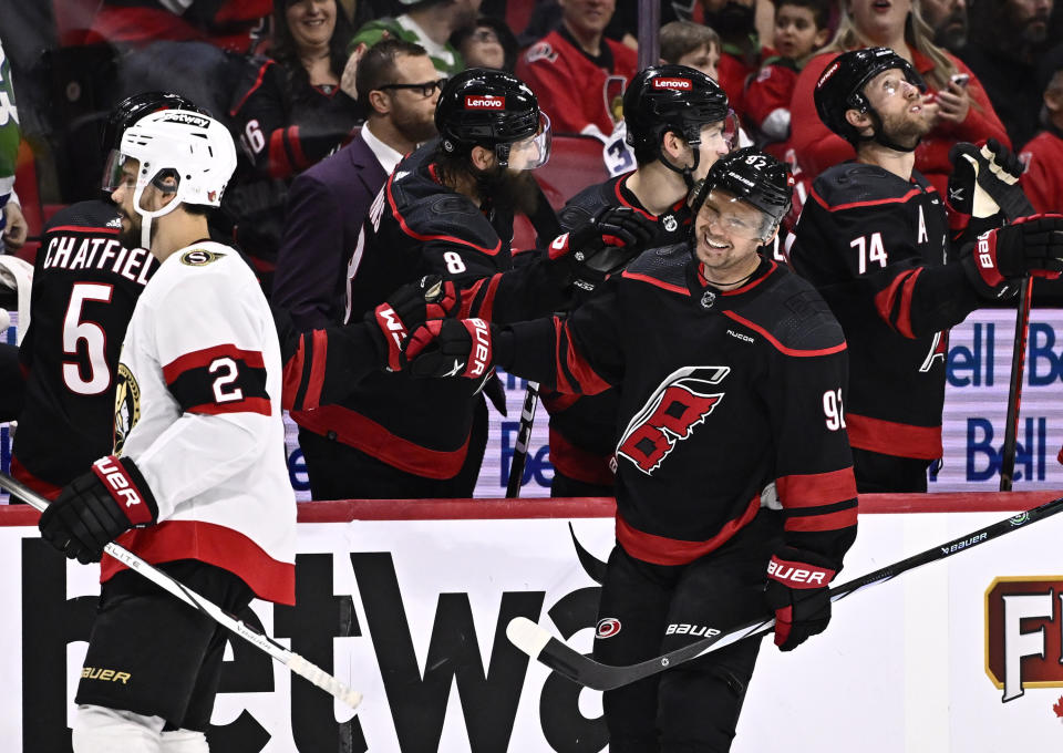 Carolina Hurricanes center Evgeny Kuznetsov (92) celebrates a goal as Ottawa Senators defenseman Artem Zub (2) skates to the bench, during the second period of an NHL hockey game in Ottawa, Ontario, on Sunday, March 17, 2024. (Justin Tang/The Canadian Press via AP)