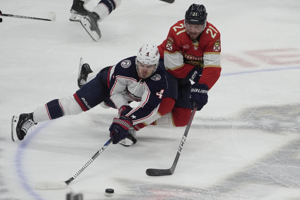 Columbus Blue Jackets center Cole Sillinger (4) and Florida Panthers center Nick Cousins (21) go after the puck during the second period of an NHL hockey game, Thursday, April 11, 2024, in Sunrise, Fla. (AP Photo/Marta Lavandier)