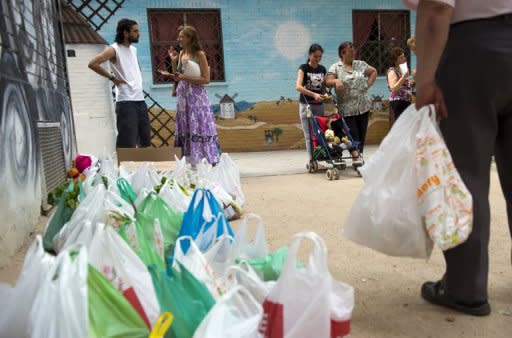 Spain's ''indignant'' protesters wait to distribute bags filled up with fruits and vegetables in a working class neighbourhood of Madrid, on June 1. The "indignants" are currently building an extraordinary street-level network to help those hardest hit by economic hardship