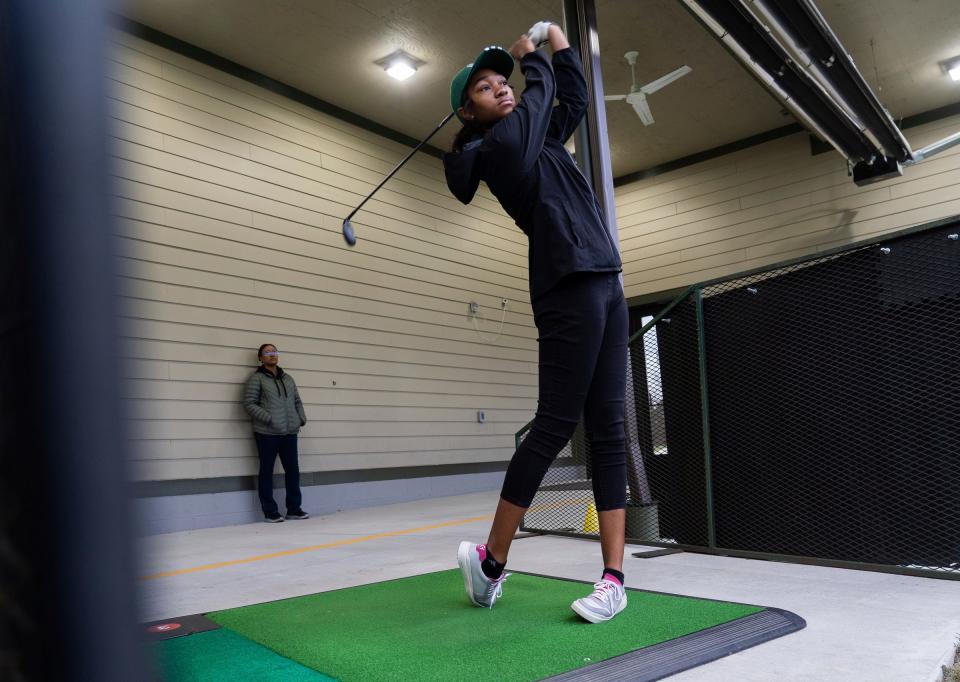 Cass Tech varsity golf player Kalista Bennett hits balls as her mother Monique Bennett looks on at the Royal Oak Golf Center in Royal Oak on Tuesday, October 17, 2023, before their Division 1 State Championship Tournament this weekend. Cass Tech is the first girl's team from Detroit to reach that level and the team is only three years old.