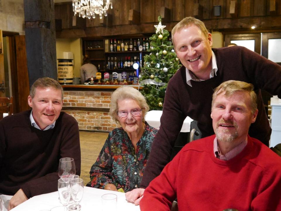 An older woman with three men who are her sons.