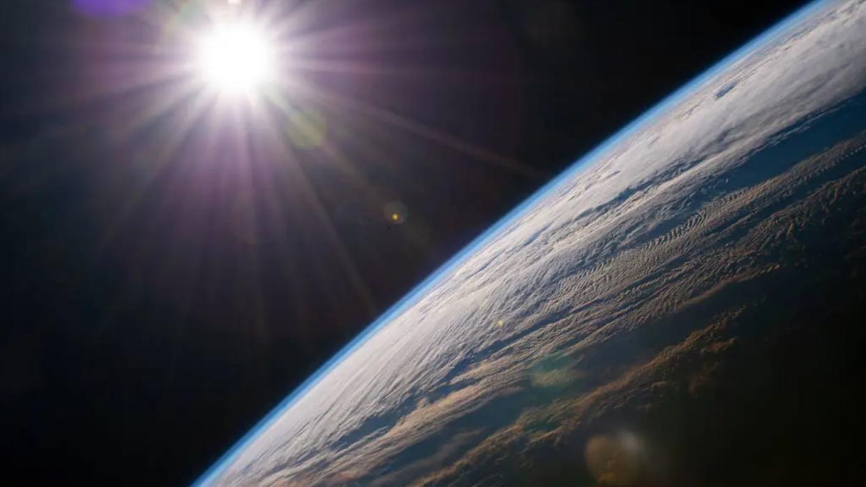  The sun rises above Earth as seen from a space station in orbit. 