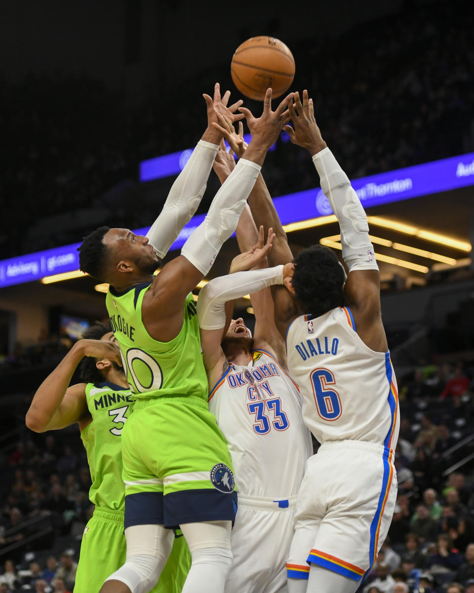 Minnesota Timberwolves center Karl-Anthony Towns, from left, Timberwolves guard Josh Okogie, Oklahoma City Thunder forward Mike Muscala and Thunder guard Hamidou Diallo go up for a rebound during the first half of an NBA basketball game Saturday, Jan. 25, 2020, in Minneapolis. (AP Photo/Craig Lassig)