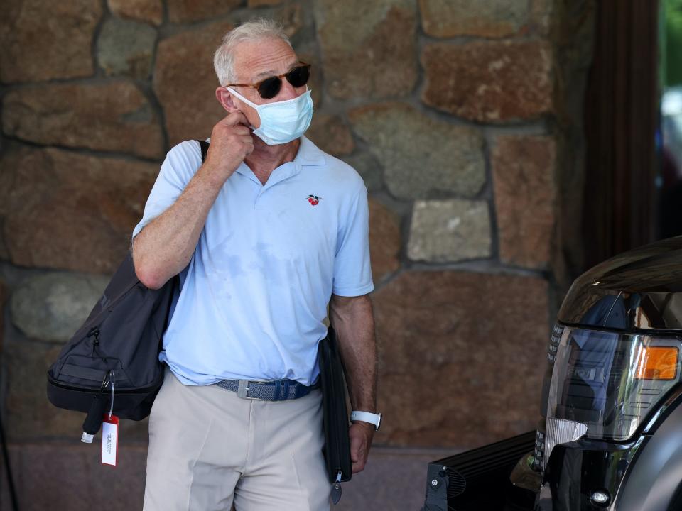 Greg Maffei adjusts face mask while walking