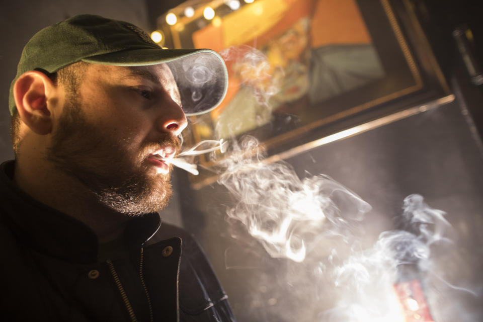 FILE - In this March 29, 2019 file photo, a man smokes marijuana at a Spleef NYC canna-cocktail party in New York. A law that took effect on Aug. 12, 2019 sets the maximum penalty to $50 for possessing less than one ounce of pot. It also turns an unlawful marijuana possession statute into a violation that's similar to a traffic ticket, instead of a criminal charge. (AP Photo/Mary Altaffer, File)