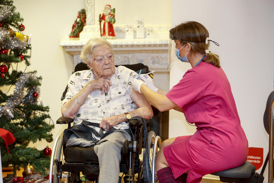 Nurse Ann-Louise Broberg injects a COVID-19 vaccine to nursing home resident Gun-Britt Johnsson in Mjolby, Sweden, Sunday, Dec. 27, 2020. Gun-Britt was the first in Sweden to receive the vaccine. (Stefan Jerrevang/TT News Agency via AP)