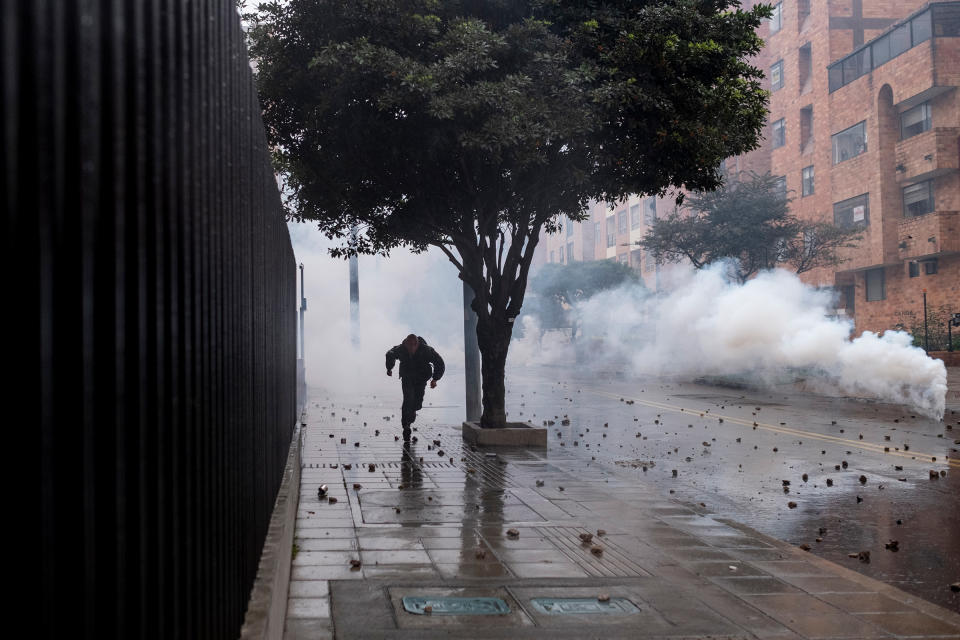 A protester flees tear gas used by the police in northern Bogotá on May 1.<span class="copyright">Santiago Mesa—Reojo Colectivo</span>