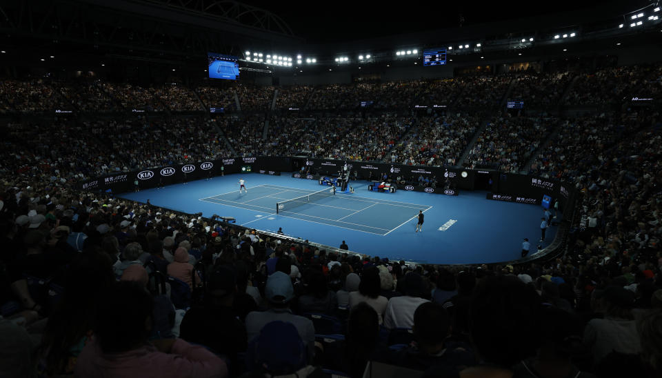 Switzerland's Roger Federer, left, makes a forehand return to Hungary's Marton Fucsovics during their fourth round singles match on Rod Laver Arena at the Australian Open tennis championship in Melbourne, Australia, Sunday, Jan. 26, 2020. (AP Photo/Andy Wong)