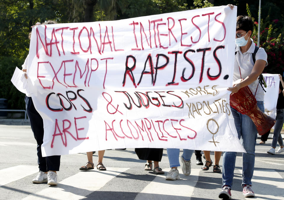 Protesters hold a banner in support of a British woman who is appealing her conviction for making false claims that she was gang raped by as many as a dozen Israelis, in front of Cyprus' Supreme Court in the capital Nicosia on Thursday, Sept. 16, 2021. Lawyers for the British woman sentenced to a four-month suspended sentence for making up the gang rape claims during a 2019 Cyprus holiday are appealing to the country's Supreme Court to overturn the conviction. (AP Photo/Philippos Christou)