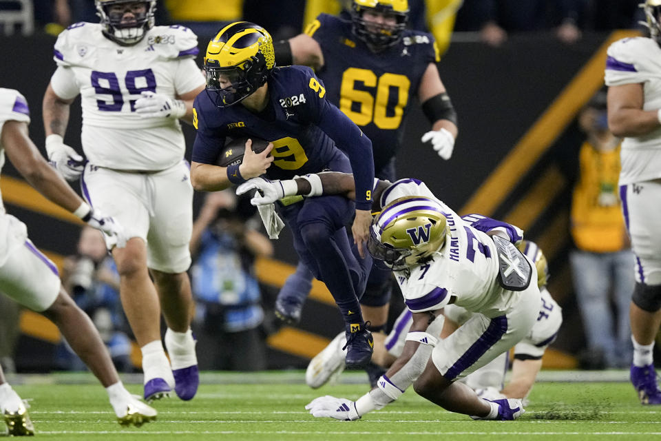 Michigan quarterback J.J. McCarthy runs past Washington cornerback Dominique Hampton during the second half of the national championship NCAA College Football Playoff game Monday, Jan. 8, 2024, in Houston. (AP Photo/Eric Gay)