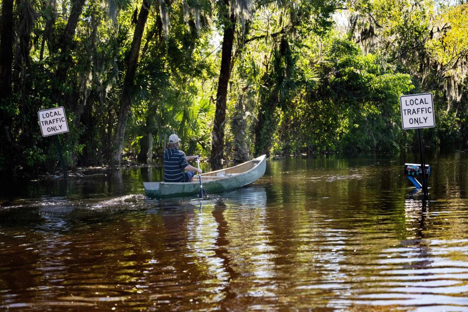 A man paddles a canoe through a flooded neighborhood in New Smyrna Beach, Florida, on September 30, 2022, after Tropical Storm Ian slammed the area. / Credit: JIM WATSON/AFP via Getty Images