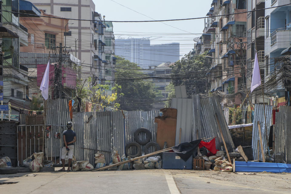 A vigilante stands behind makeshift barricade in Yangon, Myanmar Wednesday, March 10, 2021. Myanmar has been roiled by protests and other acts of civil disobedience since the Feb. 1 coup that toppled elected leader Aung San Suu Kyi's government just as it was to start its second term. (AP Photo)