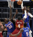 Denver Nuggets forward Paul Millsap (4) drives between New York Knicks forward Julius Randle (30) and guard RJ Barrett (9) to put up a shot blocked by center Nerlens Noel in the second half of an NBA basketball game Wednesday, May 5, 2021, in Denver. (AP Photo/David Zalubowski)