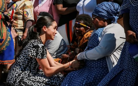 Meghan meets women outside The Justice Desk - Credit: AFP