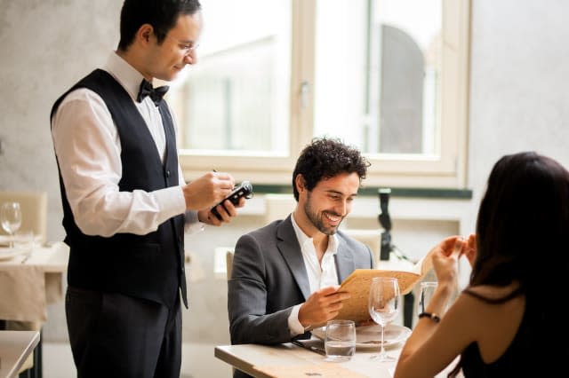 Cheerful couple with menu in a restaurant making order