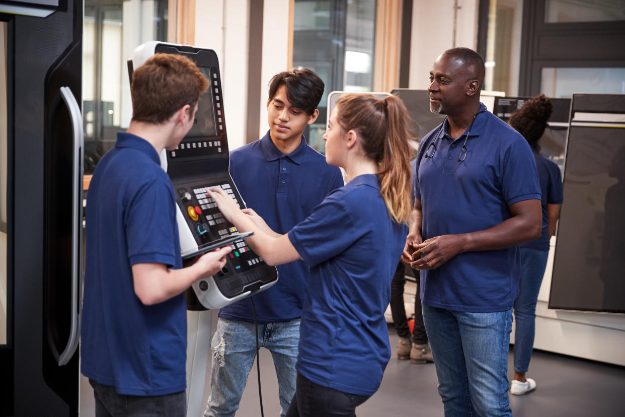 Engineer Showing Apprentices How To Use CNC Tool Making Machine