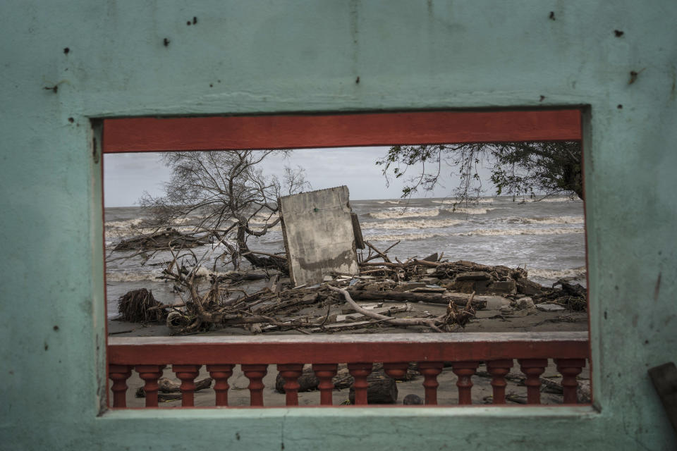 Una ventana enmarca una parte de la costa llena de escombros tras las inundaciones provocadas por la subida del nivel del mar en la comunidad costera de El Bosque, ante el Golfo de México, en México, el 29 de noviembre de 2023. (AP Foto/Félix Márquez)