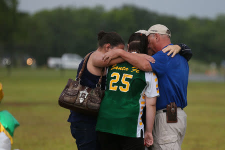 People mourn at a makeshift memorial left in memory of the victims killed in a shooting at Santa Fe High School in Santa Fe, Texas, U.S., May 23, 2018. REUTERS/Loren Elliott