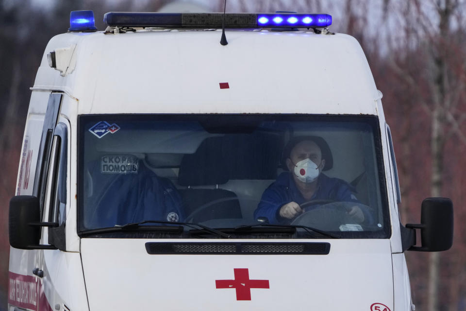 An ambulance moves towards a COVID-19 hospital in Kommunarka, outside Moscow, Russia, Thursday, Jan. 27, 2022. Russia's state coronavirus task force has reported more than 11.3 million confirmed cases and over 328 thousands deaths, by far the largest death toll in Europe. (AP Photo/Pavel Golovkin)