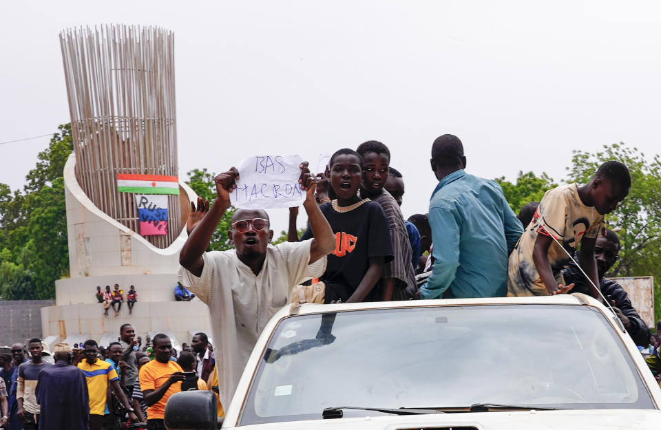 Supporters of mutinous soldiers hold a sign reading "down with Macron" as they demonstrate in Niamey, Niger, Thursday July 27 2023. Governing bodies in Africa condemned what they characterized as a coup attempt Wednesday against Niger's President Mohamed Bazoum, after members of the presidential guard declared they had seized power in a coup over the West African country's deteriorating security situation. (AP Photo/Sam Mednick)