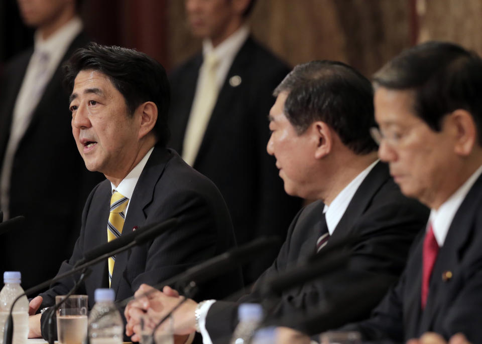 In this Sept. 15, 2012 photo, Japan's leading opposition Liberal Democratic Party presidential candidate Shinzo Abe, left, as his rivals, Shigeru Ishiba, center, and Nobutaka Machimura, listen to him during a debate at the Japan National Press Club in Tokyo. Former Prime Minister Abe blasted China at a press conference Wednesday, Sept. 18, 2012, after anti-Japanese riots flared across China. He says that if Beijing can't protect Japanese living in China it "should not enjoy membership in the international society." (AP Photo/Itsuo Inouye)