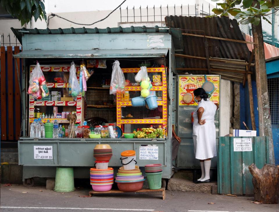 A medical worker talks to a vendor selling household goods and food for patients and their family members, outside Apeksha Hospital (Reuters)