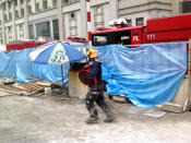 An SCDF firefighter rolling out hoses to pump water into the tunnel in order to keep the cement, where the two workers were found buried, wet, to aid extrication efforts. (Yahoo! photo/Jeanette Tan)