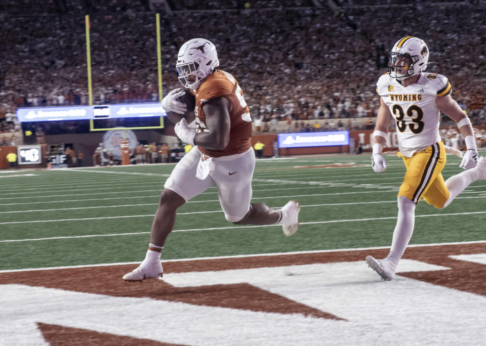 Texas defensive lineman Byron Murphy II, left, who was an eligible receiver, scores a touchdown against Wyoming defender Connor Shay during the first half of an NCAA college football game Saturday, Sept. 16, 2023, in Austin, Texas. (AP Photo/Michael Thomas)